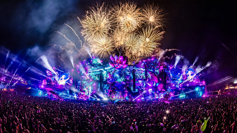 Palco do Tomorrowland Brasil em 2025 com luzes coloridas, fogos e público à noite.